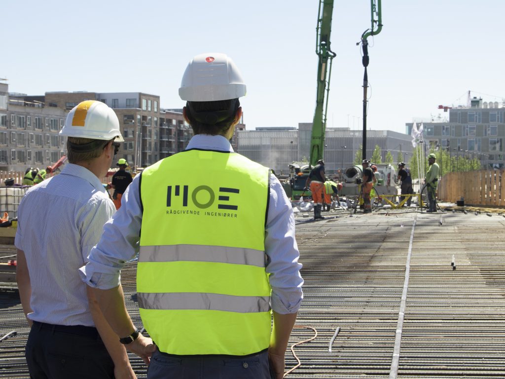 Building owners looking at construction site and using tector
