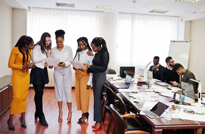 un groupe de personnes debout autour d'une salle de conférence.