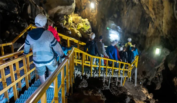 un groupe de personnes debout sur une balustrade jaune.