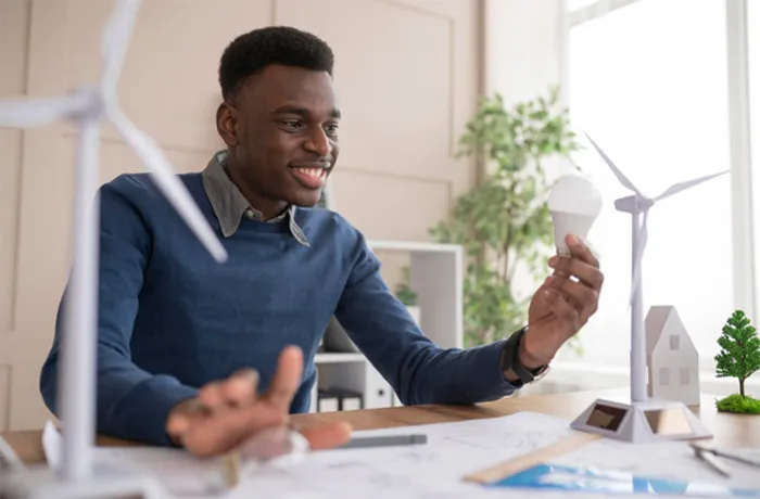 un homme assis à un bureau avec une éolienne.