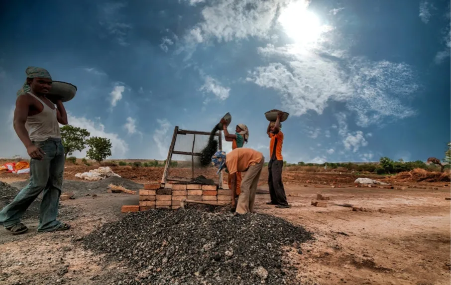 un groupe d'hommes debout autour d'un tas de briques.