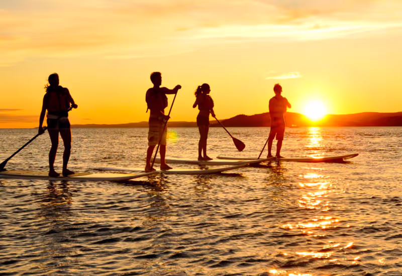 Couché de soleil et 4 personnes faisant du padel
