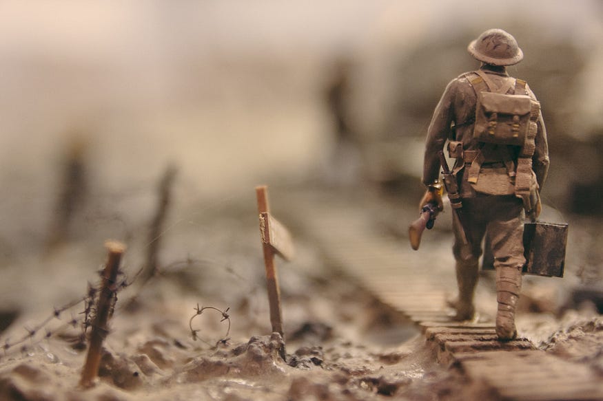 an toy world war one soldier walking across a battlefield
