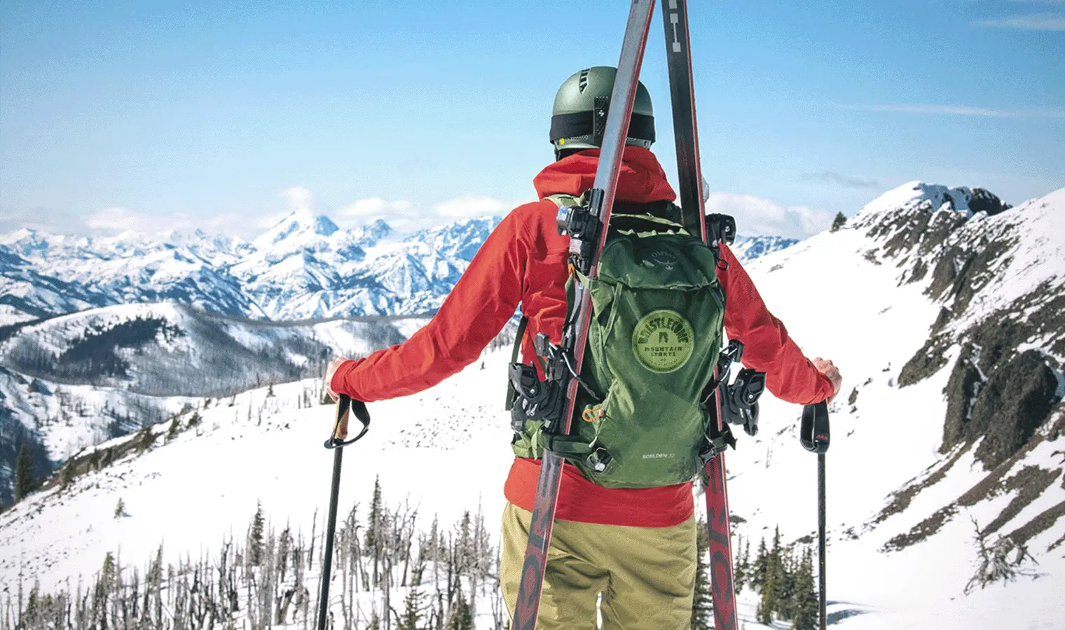 skier with backpack looking out over mountains
