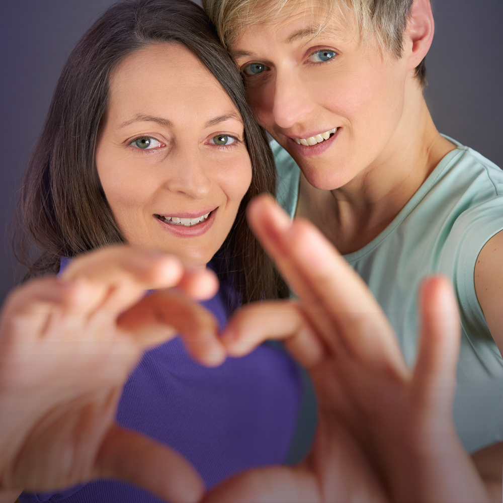 Zwei Frauen formen gemeinsam ein Herz mit ihren Händen – Symbol für ganzheitliche GesundheitsvisionZwei Frauen formen gemeinsam ein Herz mit ihren Händen – Symbol für ganzheitliche Gesundheitsvision