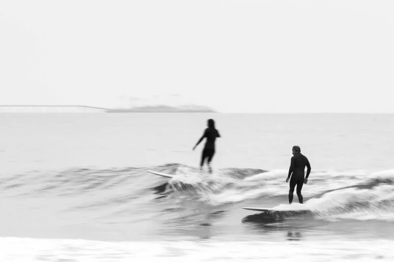 Two surfers on a wave with longboards
