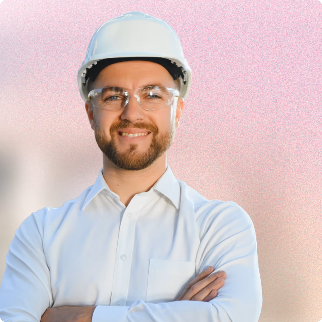 An engineer standing assessing a project, with a white shirt and orange top hat
