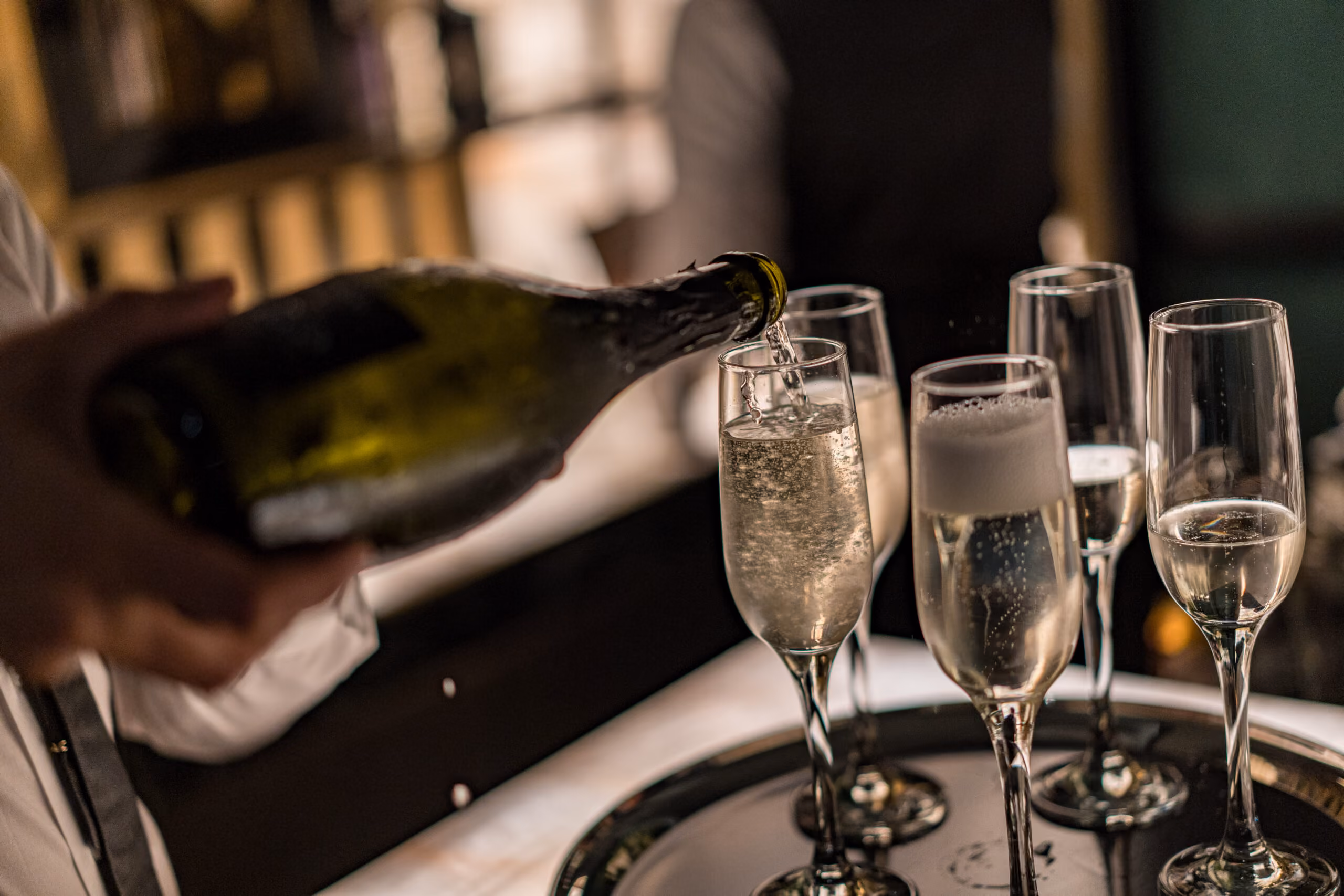 Image of champagne being poured into champange flutes 