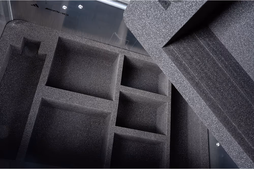 Interior view of a metal case with custom foam inserts containing rectangular compartments for secure storage of items.