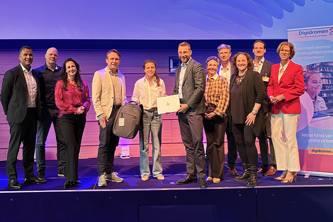 Marc Broskij, coo van KPMG en Hjalmar van Veen, country manager HP overhandigen symbolisch de eerste laptop aan Karin van der Leest van Digidromen tjdens het RSOI impact event bij KPMG.