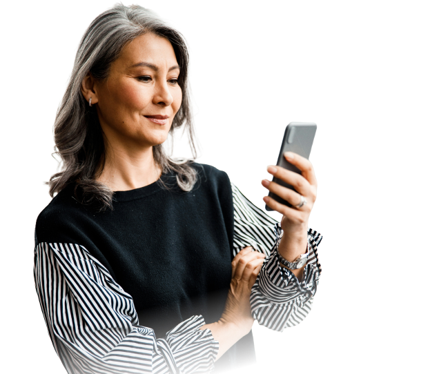 Middle-aged woman with gray hair looking at her smartphone while smiling slightly.
