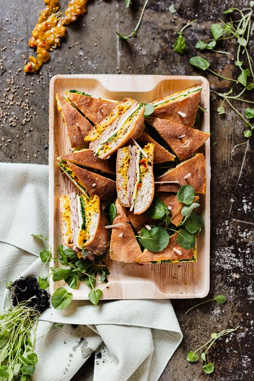A tray of mini sandwiches with freshly baked bread on a stone backdrop, catered by DSquared Hospitality Company in Seattle