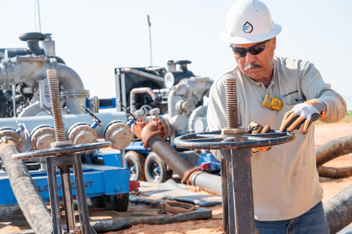 Flowpoint crew member at the valve manifold on a water transfer spread