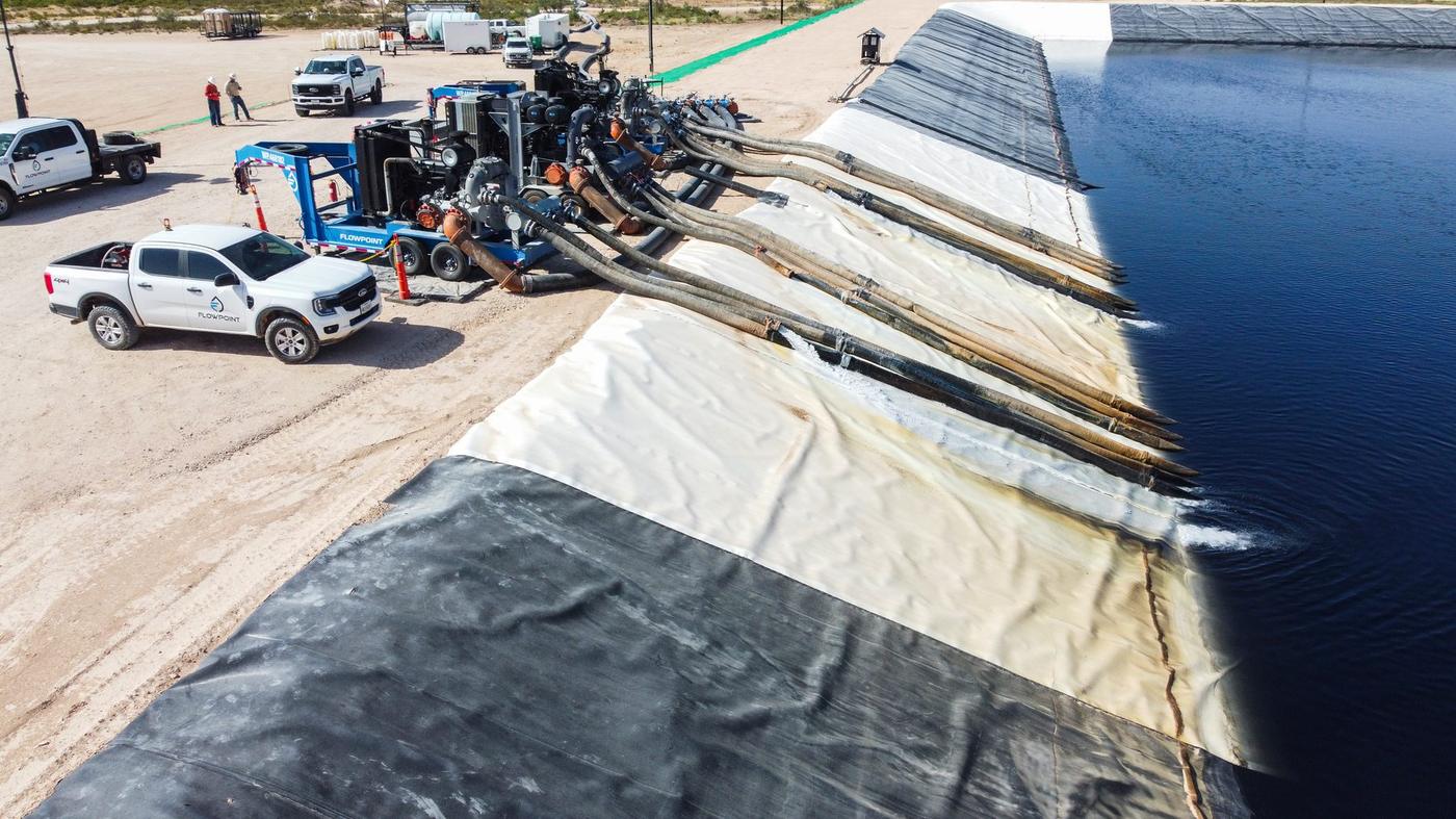 Parallel suction lines run straight down the pit liner into the water