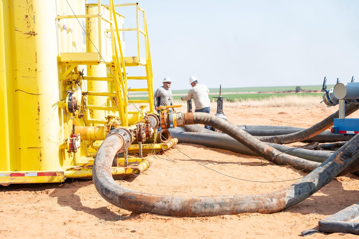 Layflat lines running from storage tanks on a Permian Basin location