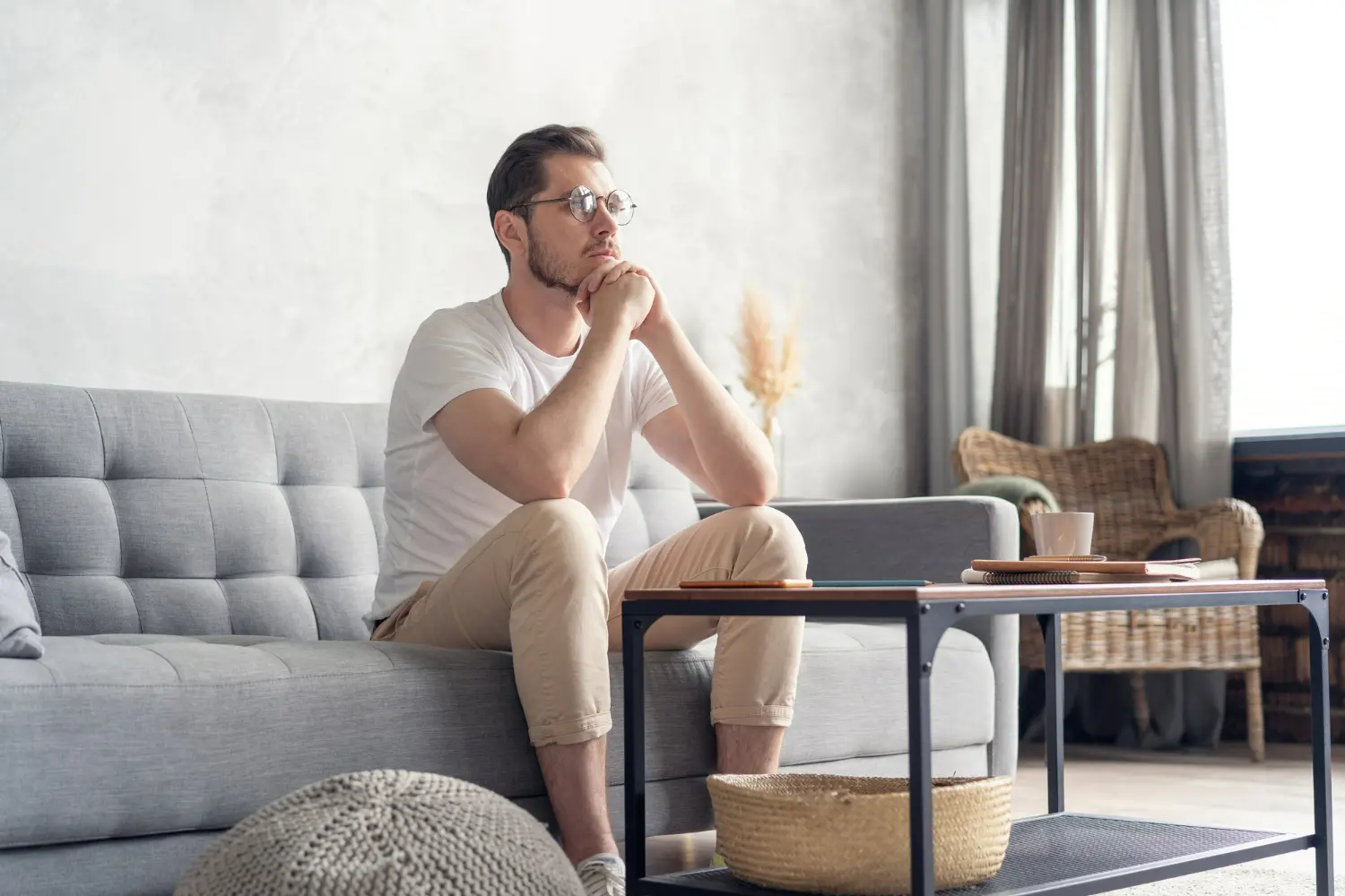 Man sitting thoughtfully on a couch, reflecting emotional growth from residential detox programs