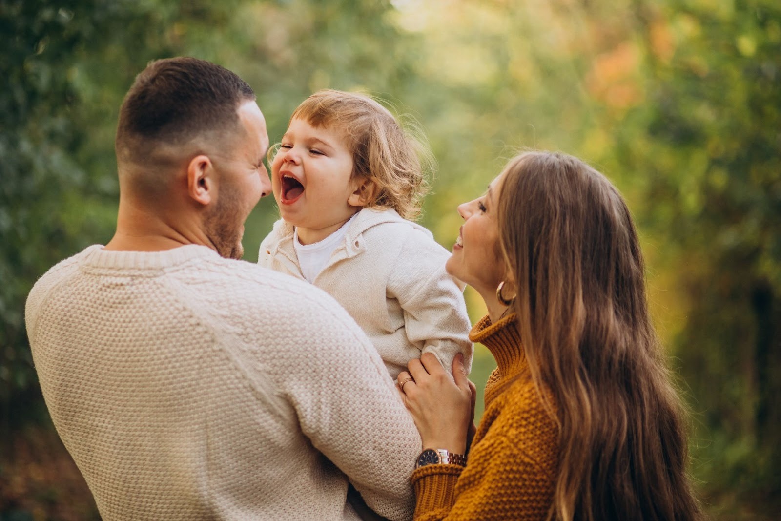A family of three sharing a happy moment together with the father holding their son