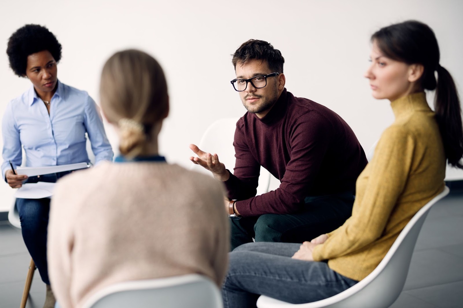 A group counseling session with four people sitting on a chair