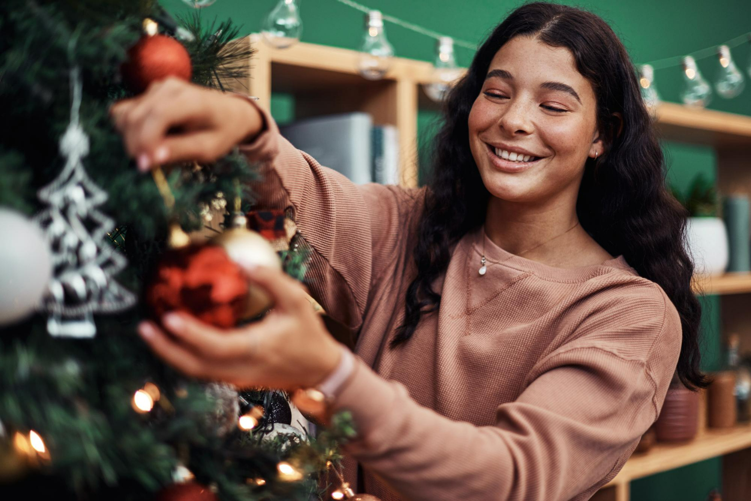 A woman decorating a Christmas tree
