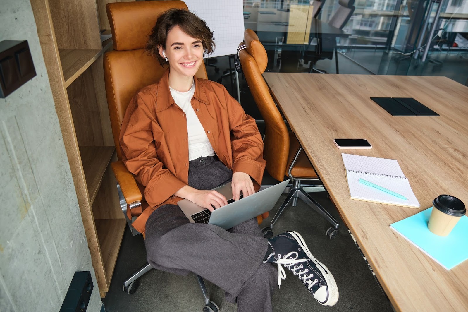A young woman sitting in an office chair and working on a laptop while attending an outpatient drug and alcohol treatment