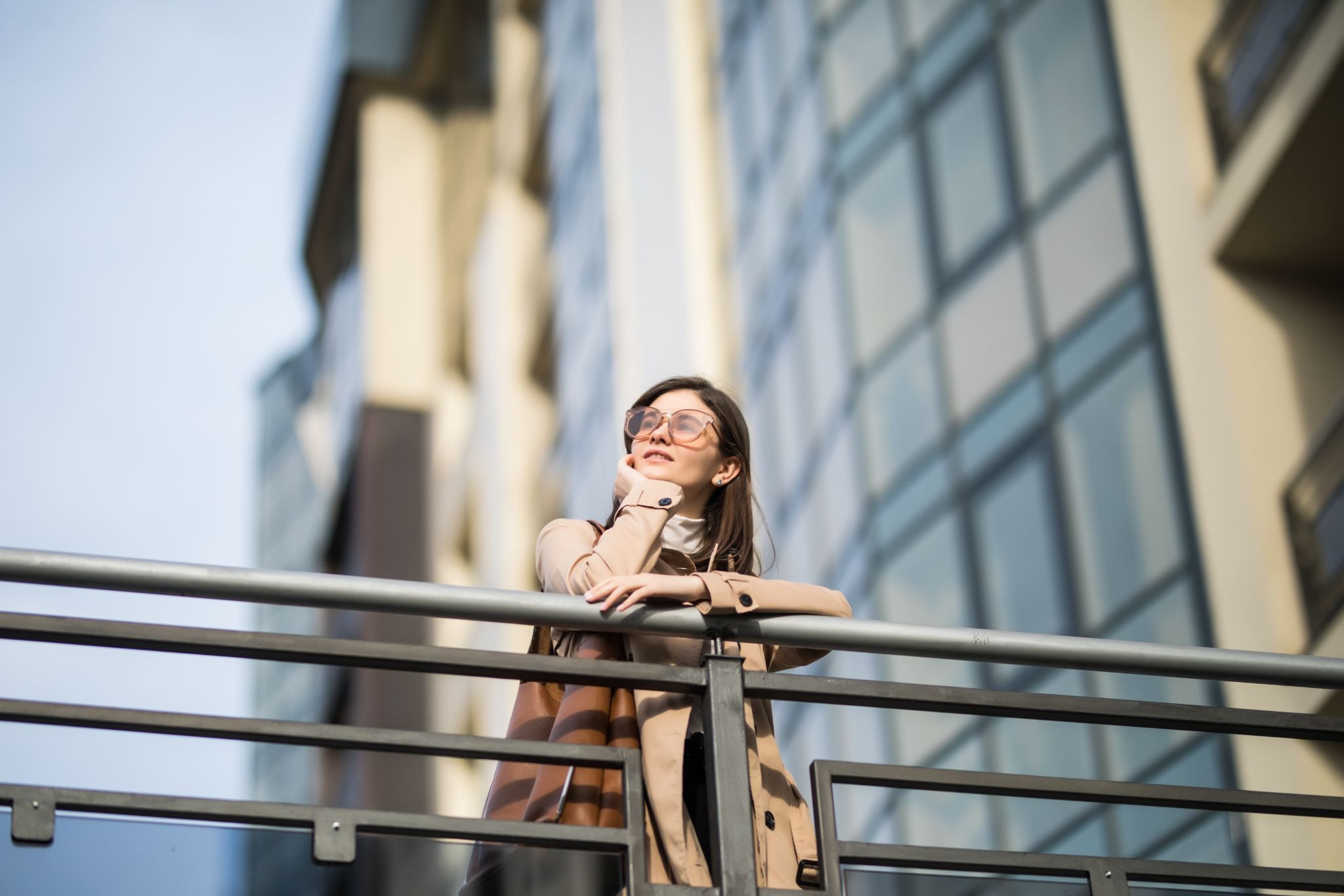Woman standing on a balcony looking ahead, symbolizing reflection, progress, and life after treatment
