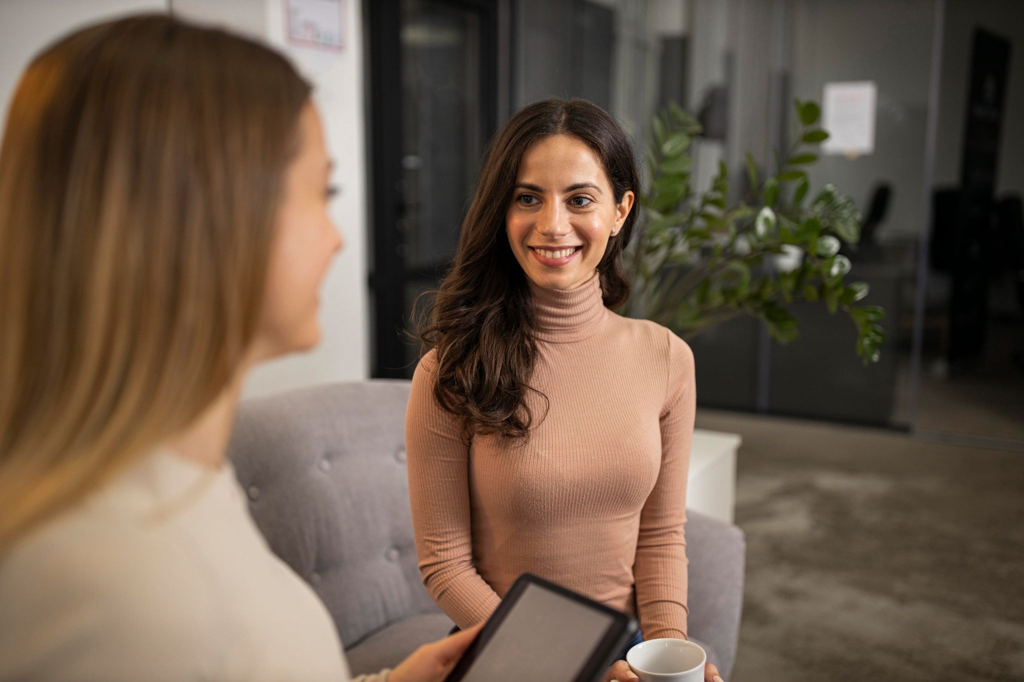 A person sits with a clinician or counselor in a comfortable office setting, engaged in a supportive conversation about treatment and recovery options