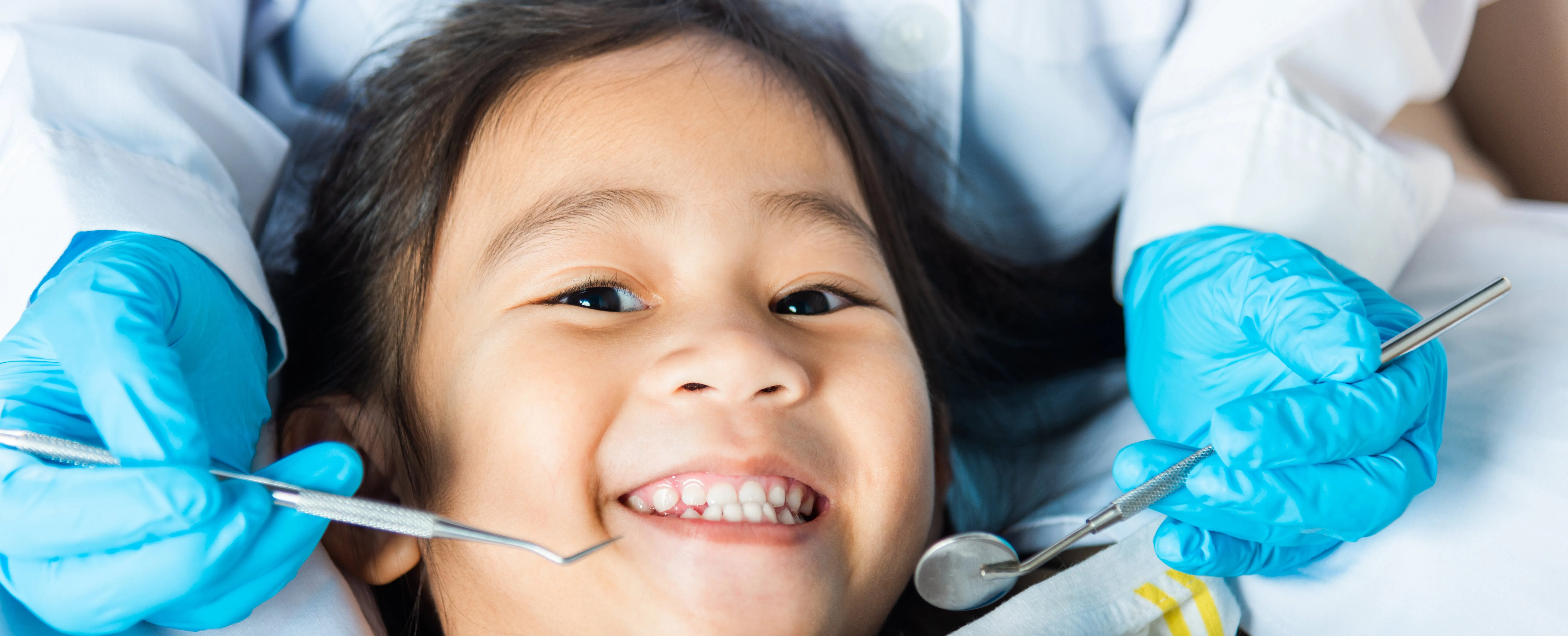 Pretty little Asian girl smiles in dentist chair in San Jose