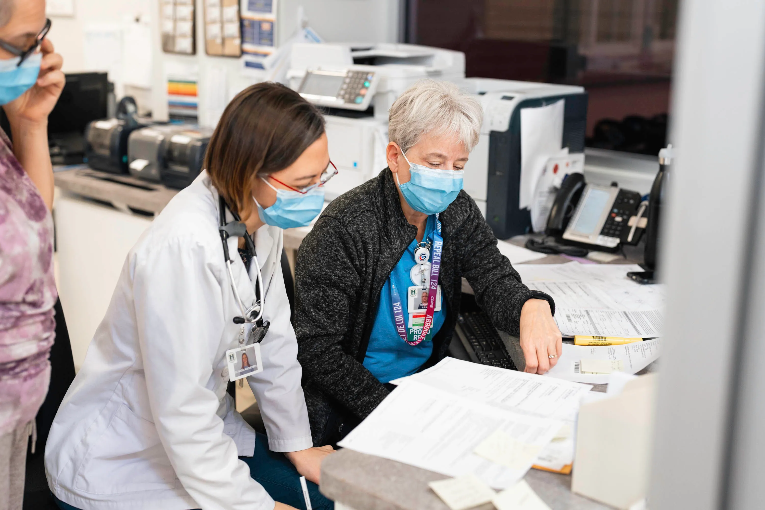 Two HGMH staff at a desk reviewing paperwork