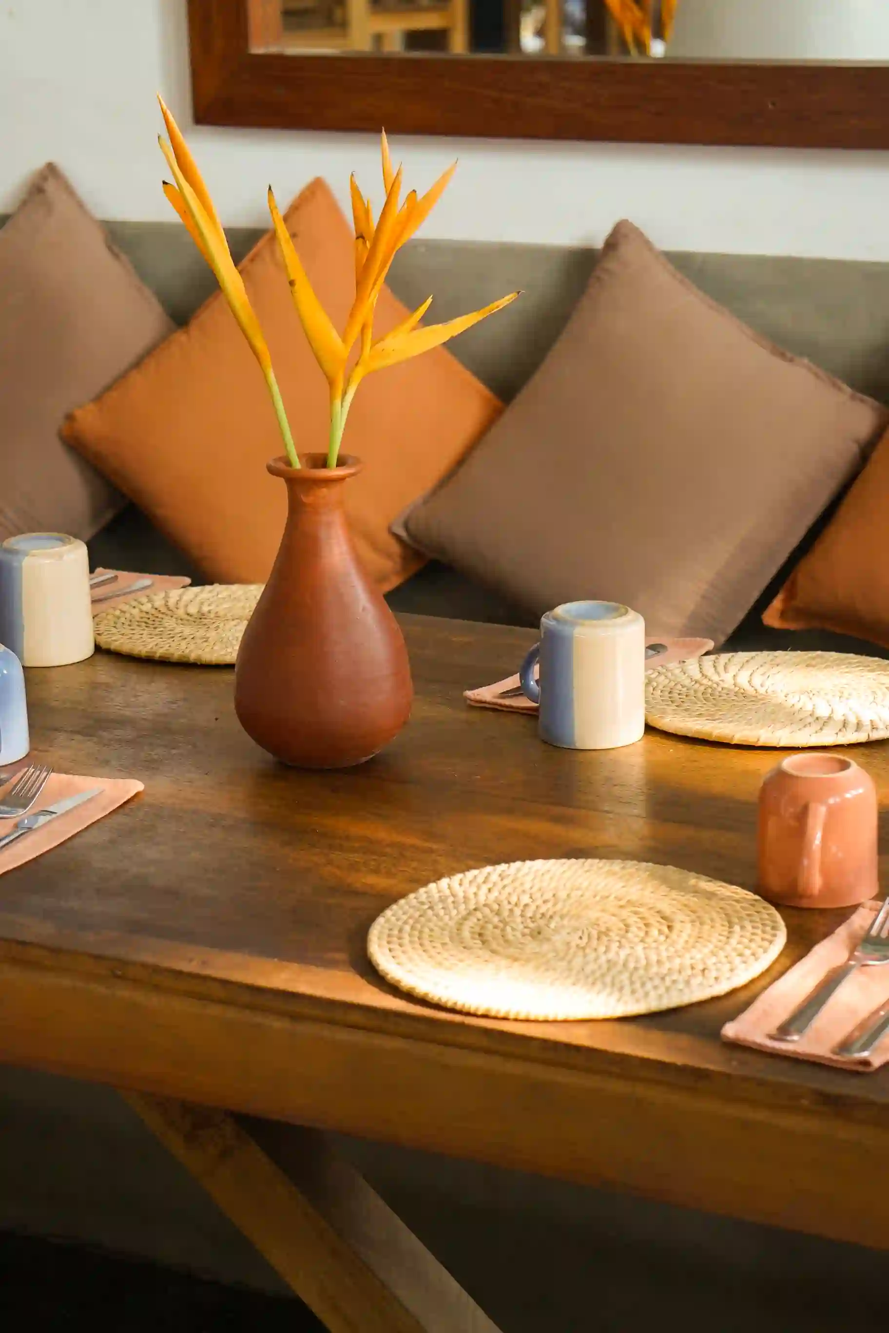 A table with a vase of flowers and a plate of food.