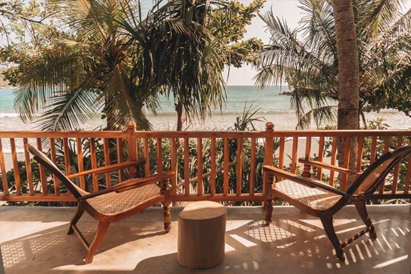 A wooden bench with a wicker seat and a wooden stool in front of it.
