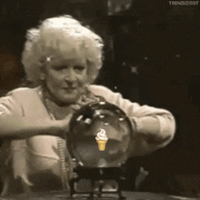 A fortune teller passing her hands over a crystal ball to read what is coming