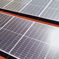Paneles solares instalados bajo luz solar intensa reflejada en ellos.