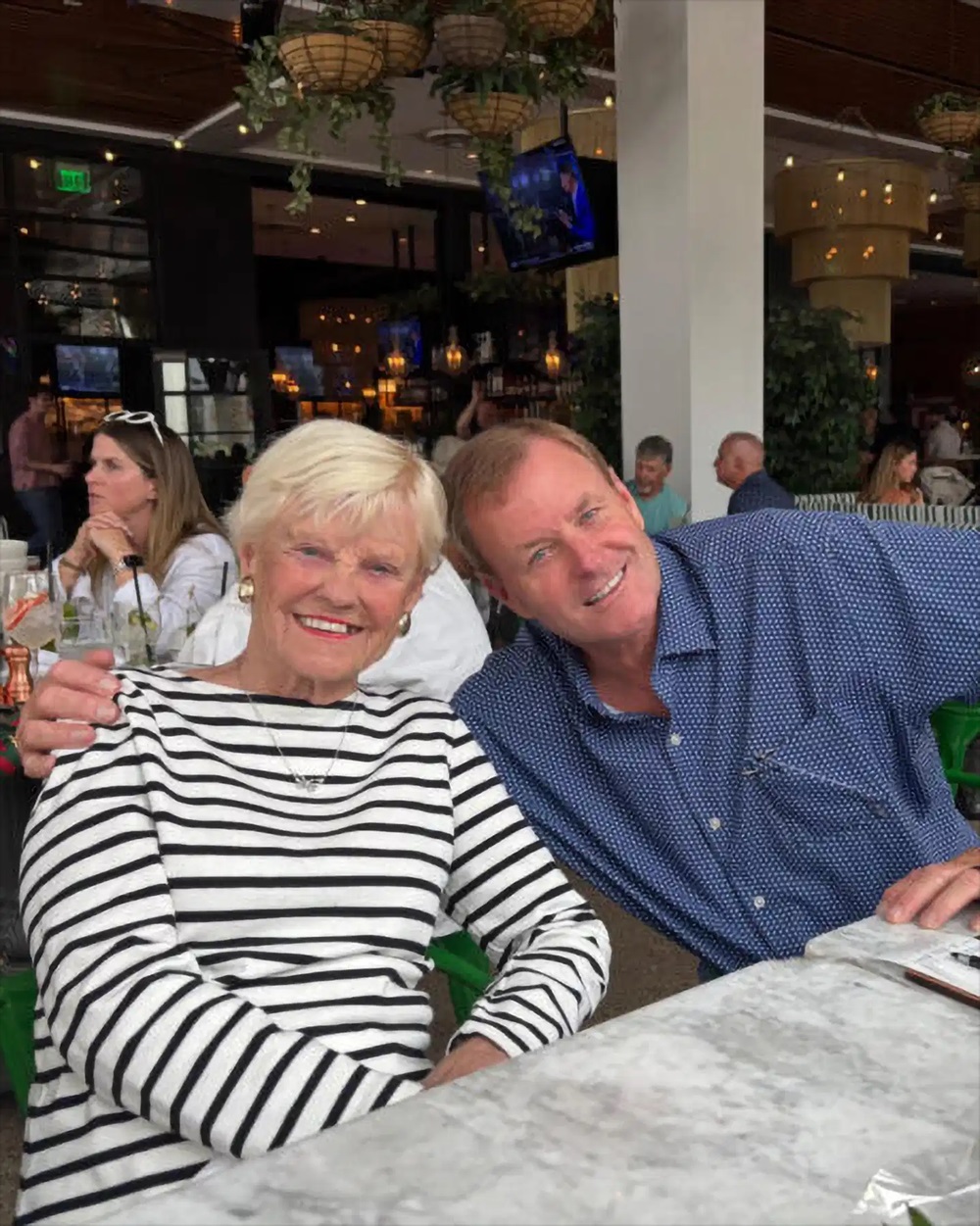 Devin Doyle posing closely with a family member inside a decorated restaurant