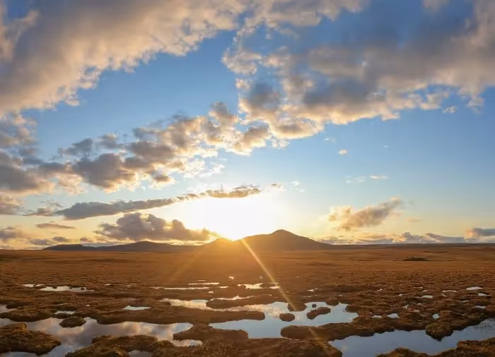 A photo of a beautiful sunrise behind clouds. 