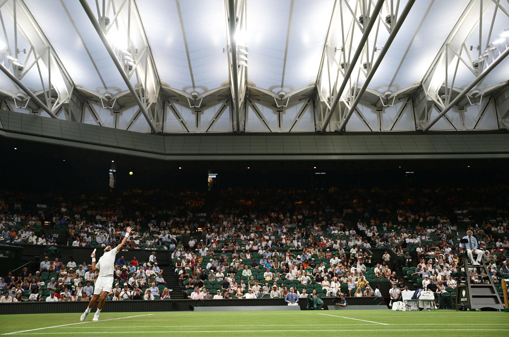 Novak Djokovic preparing to serve during a Wimbledon match.