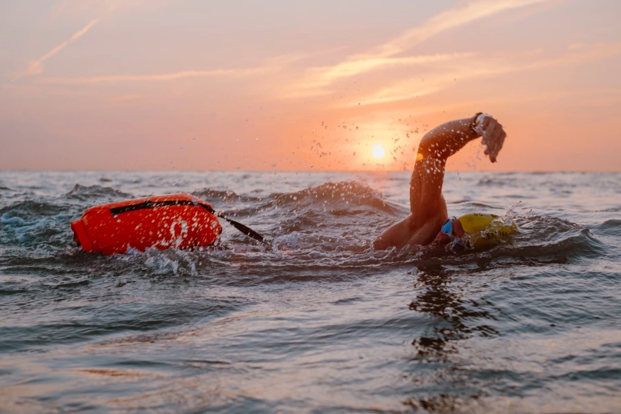 Matthieu Bonne confidently swimming in open water at sunset, exemplifying endorsement marketing by showcasing athletic achievement and brand partnership in a dynamic, inspiring setting.