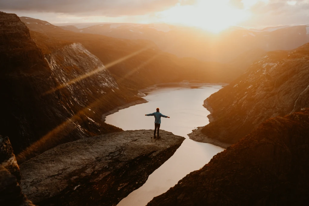 Matthieu Bonne standing confidently on a dramatic cliff at sunset, symbolizing partnership management by highlighting leadership, collaboration, and the achievement of shared goals in a powerful natural setting.