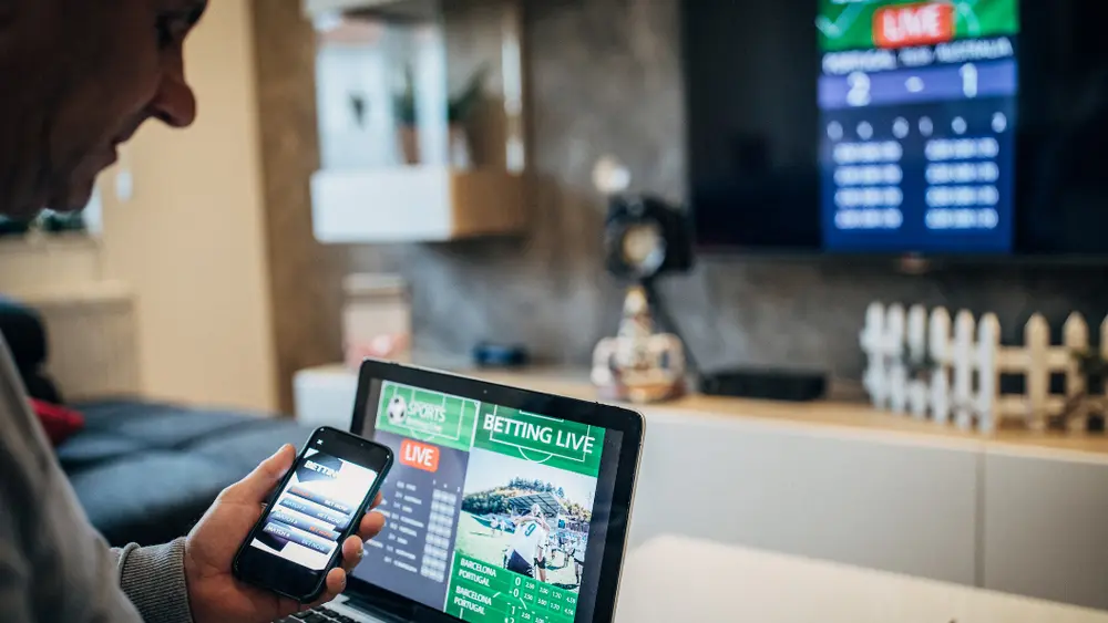 Formula 1 drivers standing in a row before the Abu Dhabi Grand Prix, viewed from behind under a large UAE flag, with Etihad branding in the background.
