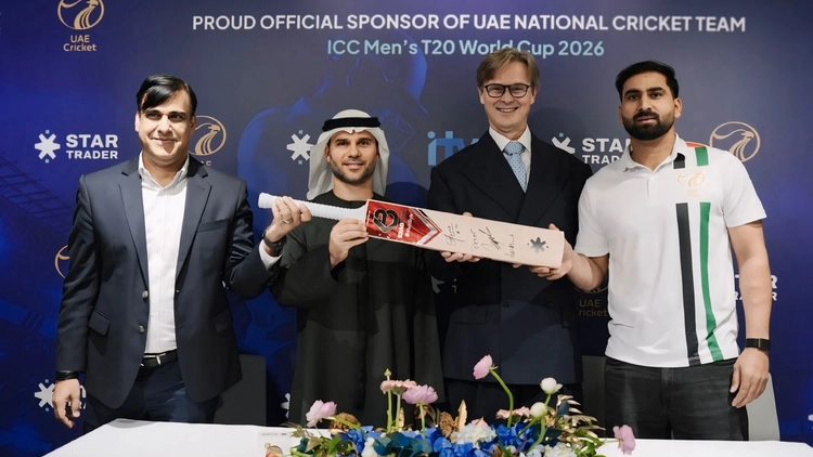 STARTRADER CEO Peter Karsten and Emirates Cricket Board COO Subhan Ahmad sign sports sponsorships deal for UAE National Cricket Team's ICC Men's T20 World Cup 2026 jerseys, holding bat amid ICC backdrop.