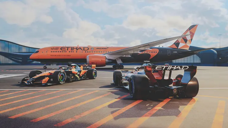 Etihad Airways Boeing 787 Dreamliner with McLaren F1 car livery next to orange McLaren race cars on tarmac, showcasing sports marketing partnership and F1 sponsorship branding.