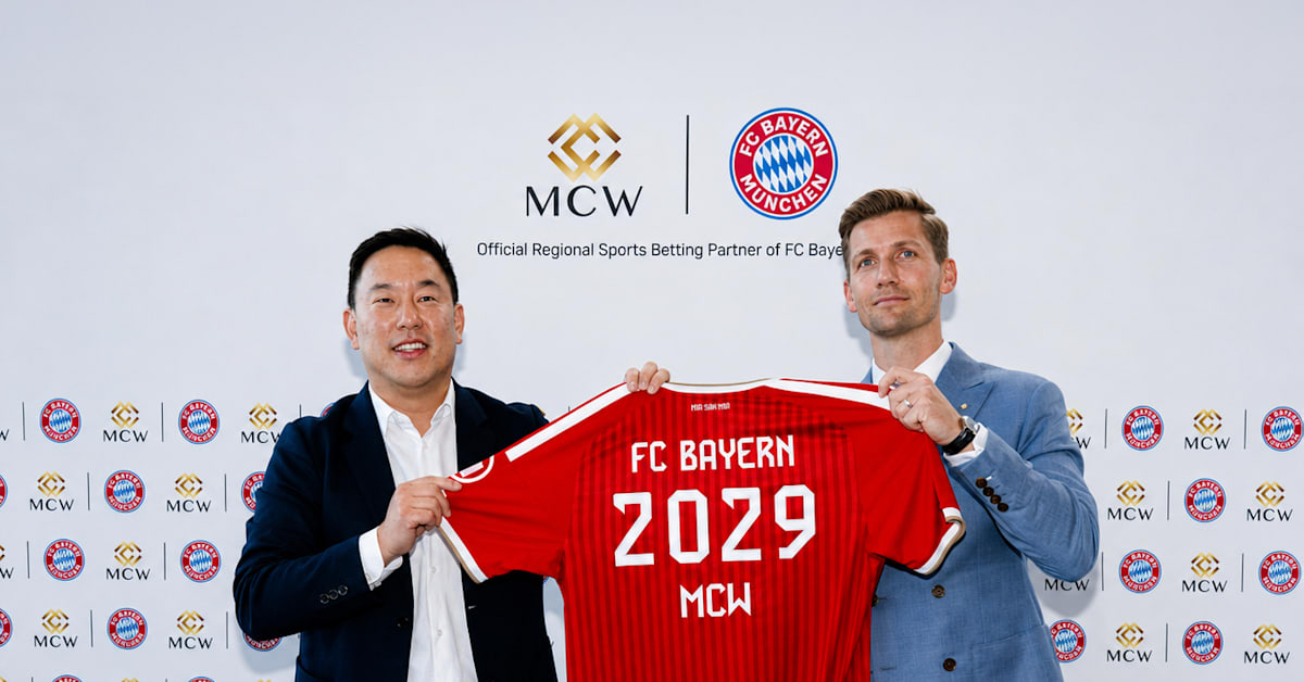 FC Bayern and MCW executives hold a red Bayern shirt printed 2029 MCW in front of a logo wall, marking the iGaming regional partnership for Asia