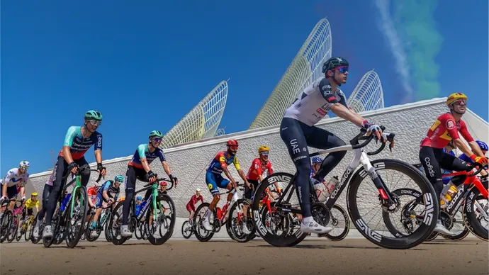 UAE Tour peloton racing past the Zayed National Museum in Abu Dhabi, the cycling race backed by AD Ports Group sports sponsorship