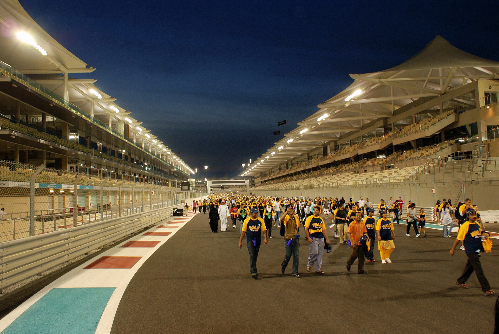 Fans walking on the track between the grandstands at Yas Marina Circuit, Abu Dhabi, a top UAE sports sponsorship venue