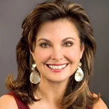 Smiling woman in red top with wavy brown hair and dangling earrings