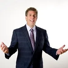 Businessman in navy suit gesturing with open hands during presentation