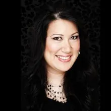 Smiling professional woman in black top against dark background