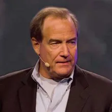 Speaker wearing a headset microphone giving a presentation on stage
