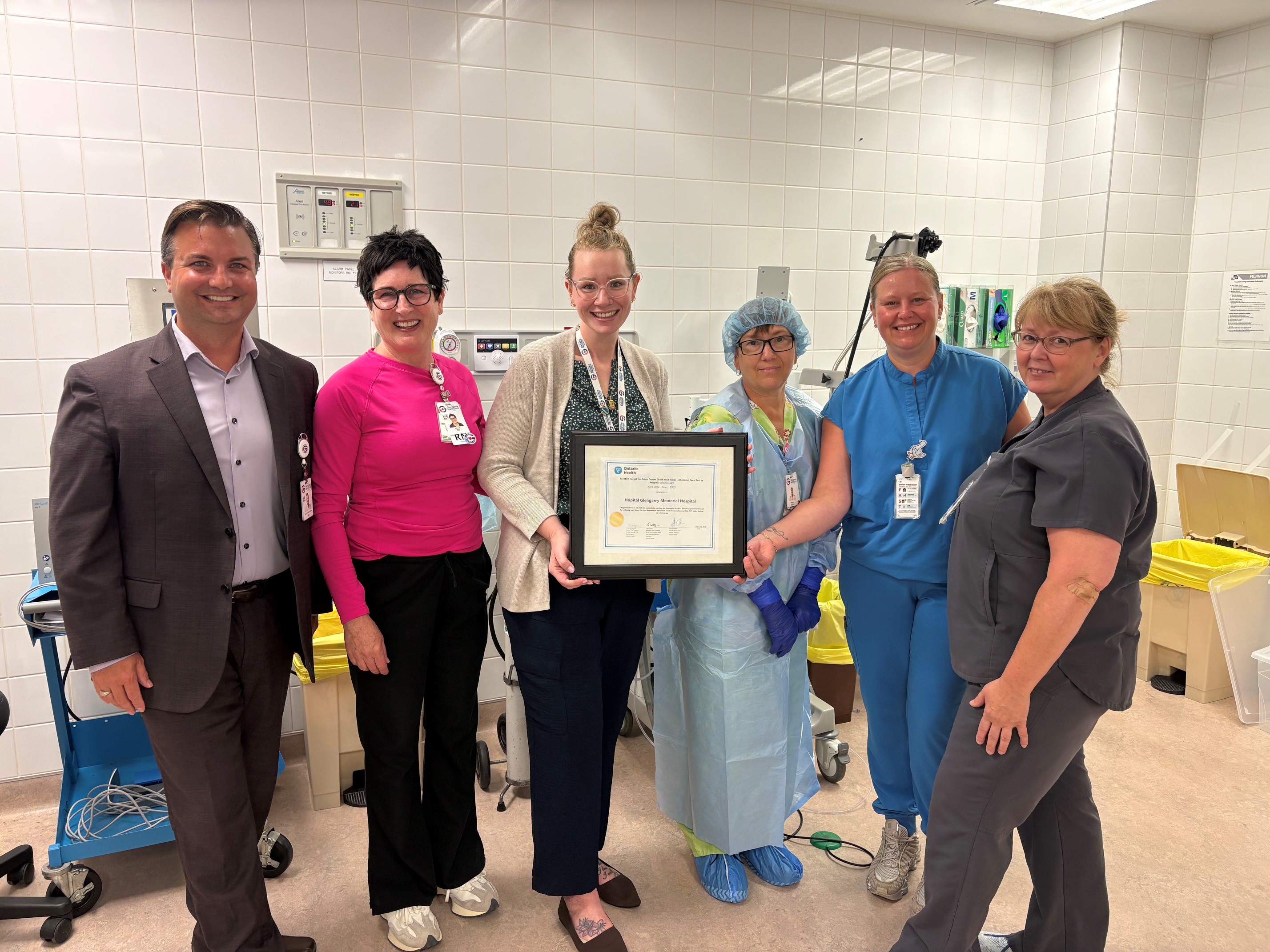 Staff holding certificate received from Ontario Health