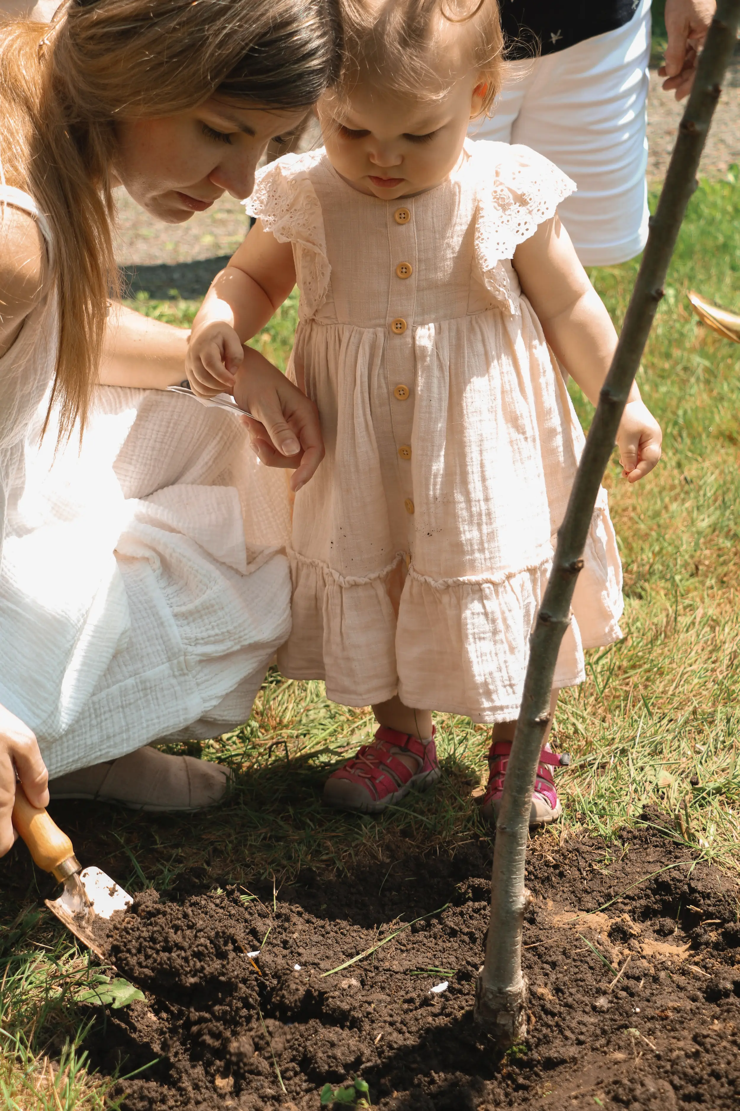 Photo d'un enfant et sa mère qui plante un arbre