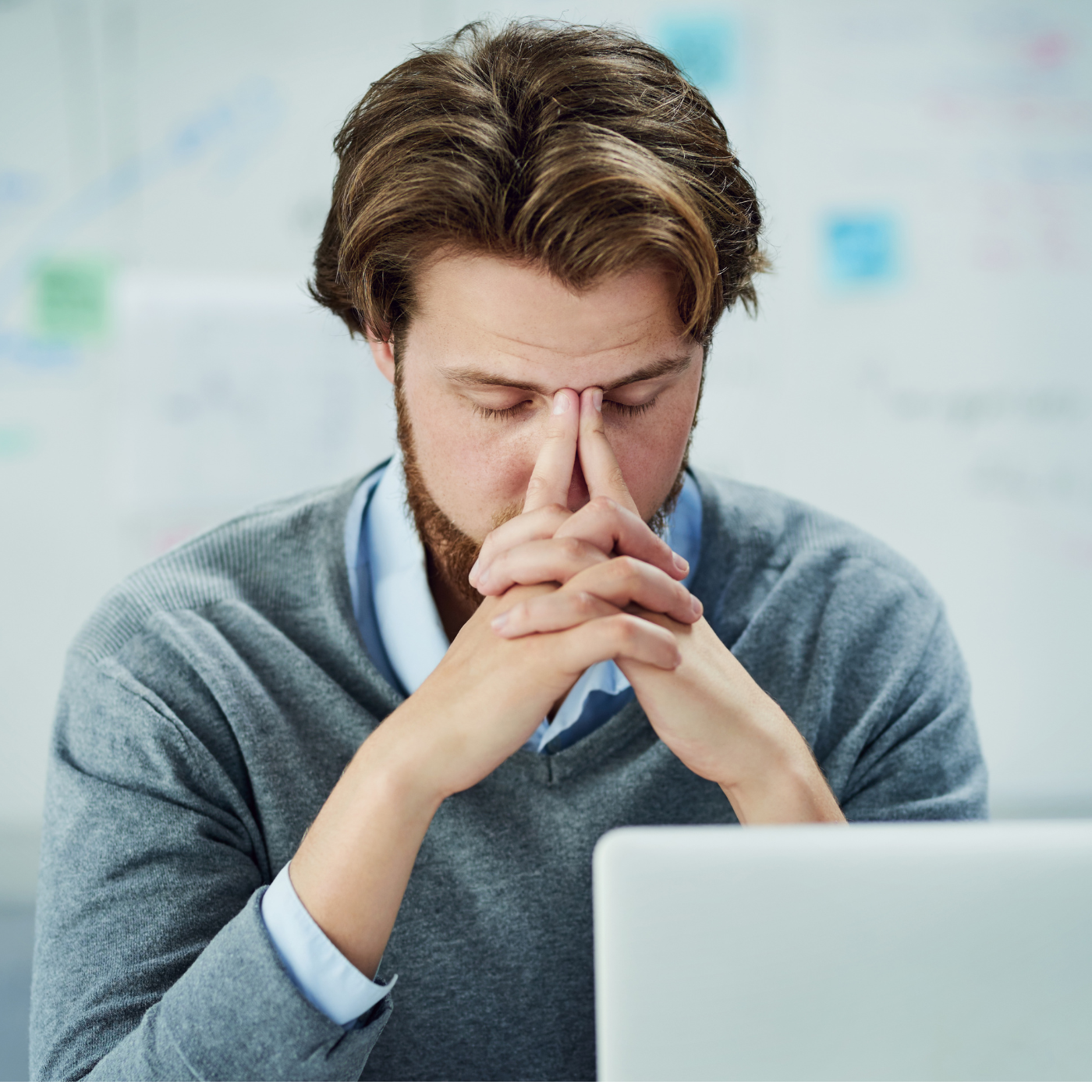 Stressed out business man putting his face in his hands. 